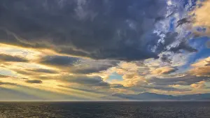 Cloudy Atmospheric Images Prints: Dramatic sky over the sea with sun rays breaking through the clouds