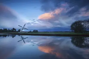 Prints of Dramatic stormy sunset over Dutch windmill by river, Holland River Prints: Dramatic Stormy Sunset Print over Dutch Windmill by River