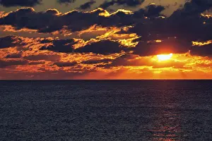 Dramatic Sunset Prints: Dramatic sunset at the sea, sunbeams behind clouds