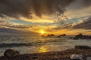 Sunset Over The Sea Prints: Dramatic sunset sky over beach rocks and waves