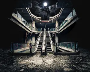 Dark Night Sky Prints: Dramatic view of damaged escalators in abandoned building