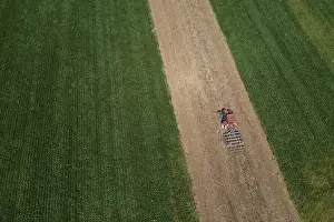 Agricultural Landscape From Above Prints: Drone view, tractor at work between green fields