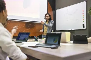 Office Communication Skills Prints: A dynamic office setting with a diverse team engaged in a presentation