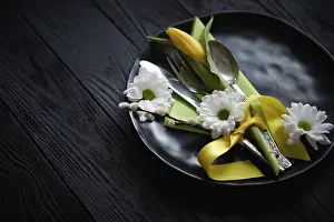 Black Wooden Background Prints: Easter spring table dishware composition with yellow tulip flower