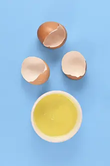 Healthy Eating Protein Source Prints: Egg white in bowl next to broken eggshells on yellow background