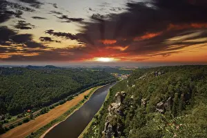 Elbe Sandstone Mountains Landscape Prints: The Elbe meanders through a dense forest under a dramatic sunset sky