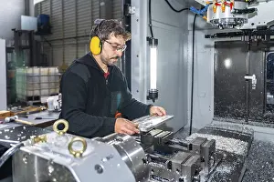 CNC Milling Machine Operator Prints: Engineer working with a milling cnc machine using safety gear