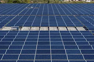 Eco Friendly Architecture Prints: Extensive array of blue solar panels covering a rooftop