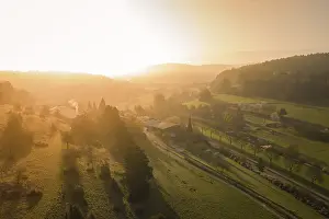 Atmospheric Sunset In Europe Prints: Extensive panorama of fields and forests in the soft light of sunset