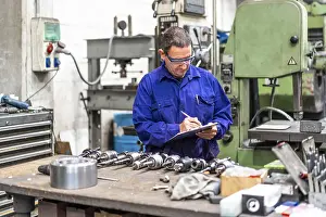 Factory Worker Prints: Factory worker operator in the numerical control sector making a report