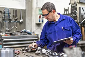 Factory Worker Prints: Factory worker operator of the numerical control sector measuring the drill bits