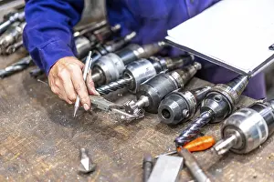 Factory Worker Prints: Factory worker operator of the numerical control sector measuring the drill bits