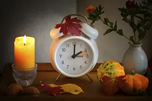Daylight Saving Time Prints: Fall back, time change on a white alarm clock after daylight saving time