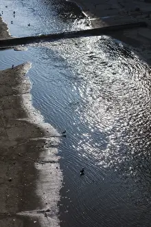 Urban River Scene Prints: Falling sunlight on a river in the city
