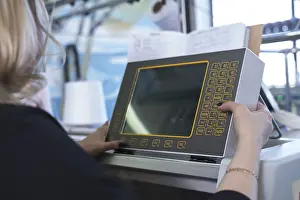 Modern Industrial Architecture Prints: Female operator setting programme at knitting machine control panel view