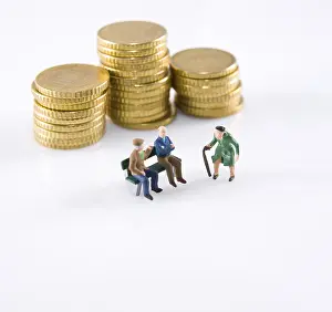 Euro Coin Stack Prints: Figurs of two senior citizens in front of a stack of coins