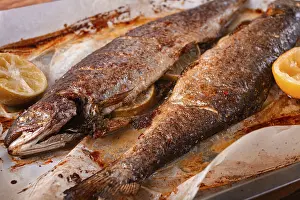 Grilled Fish Recipe Prints: Two fish are being cooked on a baking sheet in a home kitchen