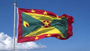 Prints of The flag of Grenada, Caribbean, flutters in the wind, isolated, against the blue sky Related Prints: The Flag of Grenada Print - Caribbean Island Scene