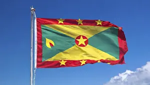 Prints of The flag of Grenada, Caribbean, flutters in the wind, isolated, against the blue sky Related Prints: The Flag of Grenada Print - Caribbean Island Scene