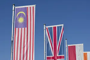 Blue Skies And Flags Prints: Several flags of different countries fly side by side under a clear blue sky