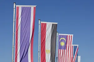 Southeast Asia Flags Prints: Several flags of different countries fly side by side under a clear blue sky