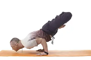 Yoga Wellbeing Exercise Prints: Focused athletic man posing in difficult yoga pose