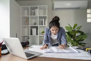 Modern Office Space Prints: A focused engineer analyzes blueprints at her desk
