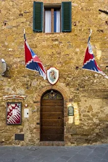 Prints of Gate of an old building with flags and advertising poster, Montisi, Province of Siena, Tuscany Region, Italy Poster Prints: Italian Old Building Gate Print, Montisi, Tuscany