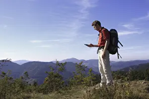 Mountain Peak Prints: Geocacher checking the coordinates with a GPS navigation system on Mt