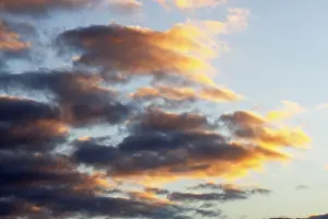 Cloudy Sky With Sunlight Prints: Glowing clouds in the evening sky at sunset