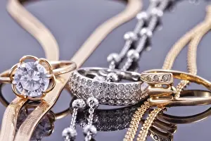 Reflective Surface Prints: Gold ring, earrings and chains on a reflective surface