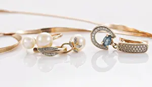 Semi Precious Stones Prints: Gold ring, earrings and chains on a reflective surface