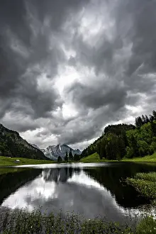 Cloudy Skies In Middle Europe Prints: Groppelensee with reflection of the Altmann summit in the background under a threatening cloudy sky