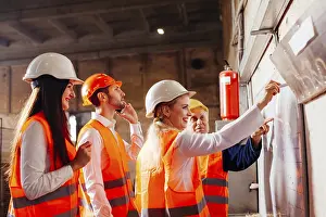 Workplace Communication Skills Prints: The group of workers stands next by the flip chat and plans work