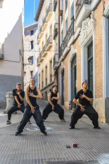 Prints of Group of four young dancers expressing movement and energy through a choreographed street performance in a narrow european alley, showcasing contemporary dance Dance Prints: Contemporary Dance Print: European Alley Street Performance