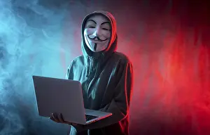 Hacker Anonymous Mask Prints: Hacker with anonymous mask with a computer and with a background of smoke and colored led