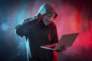 Hacker Symbol Prints: Hacker with an anonymous mask with a computer and making a fight symbol