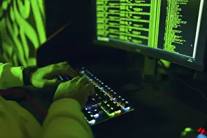 Online Safety Measures Prints: Hacker in hoodie working hacks code site on personal computer
