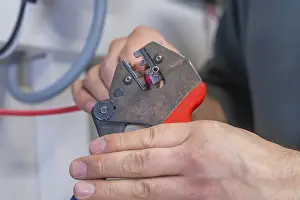 Industrial Craftsman Prints: Hand holding pliers that process a cable