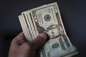 US Currency Prints: A hand holds a stack of US currency
