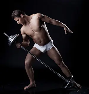 Athletic Training Prints: Handsome athlete lifting weights in studio