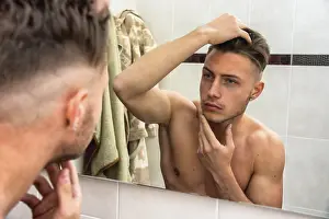 Male Beauty Standards Prints: Handsome man looking at his face in mirror