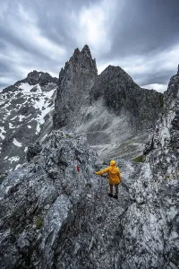 Hiker In The Alps Prints: Hiker looking at mountains under dramatic clouds