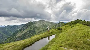 Mountain Lake Reflections Prints: Hiker is reflected in a small lake