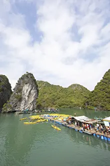 Vietnamese Tourist Attraction Prints: Holidaymakers queue for a kayak on a jetty