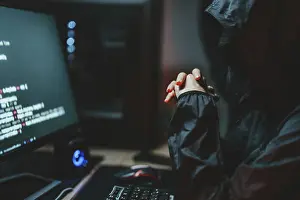 Virus Protection Prints: Hooded Hacker coding destroy online data system with virus ransomware in server