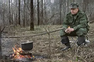 Campfire Cooking Prints: The hunter makes a dinner on a bonfire