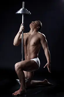 Fitness Studio Shot Prints: Image of strong young guy posing with rod