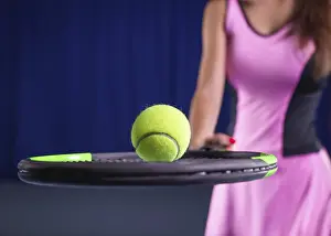 Young Woman Tennis Prints: Image of a tennis ball on the background of the strings of the racket