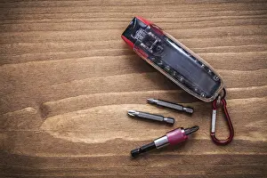 Construction Concept Image Prints: Interchangeable screwdriver bits in container on wood board construction concept
